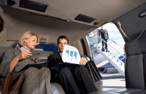 a businessman and a corporate business woman is enjoying a luxury LaGuardia limo service in NYC