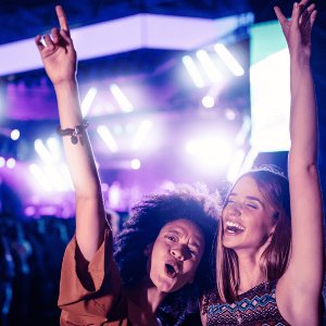 Two girls are enjoying a concert after taking luxury concert rides in NJ