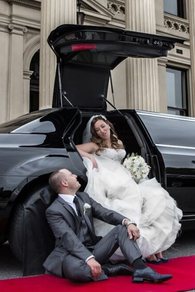 A couple sitting together in a wedding limo