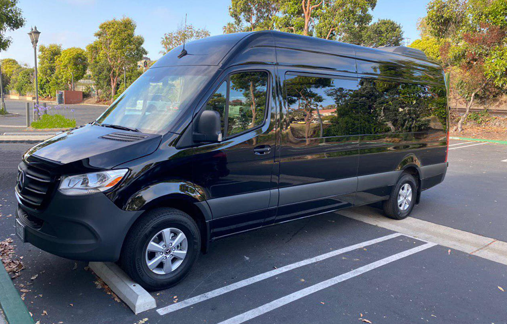 A sprinter black rental van is parked in parking lot